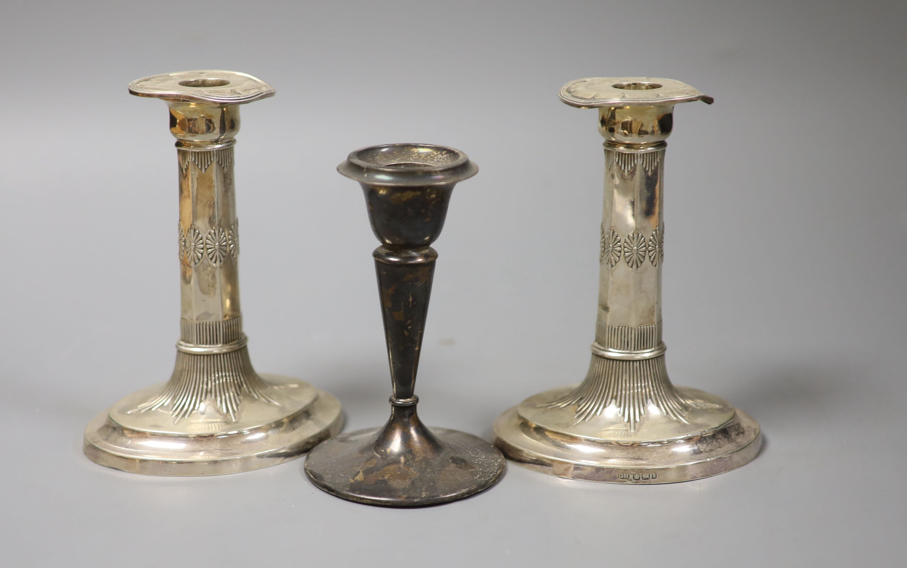 A pair of late Victorian silver dwarf candlesticks, George Howson, Sheffield, 1900, 15.2cm and one other silver candlestick, all weighted.